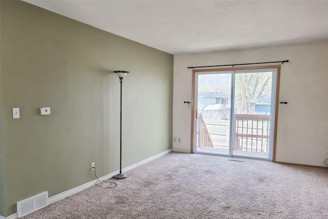 spare room with baseboards, visible vents, and carpet