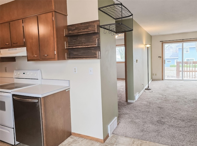 kitchen with light colored carpet, visible vents, light countertops, under cabinet range hood, and electric range