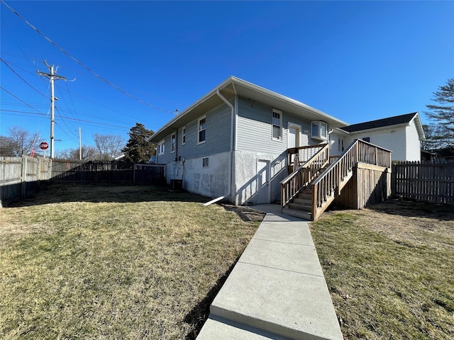 1144 Euclid Ave, Des Moines, IA 50313 - exterior space featuring cooling unit, a fenced backyard, stairway, and a yard