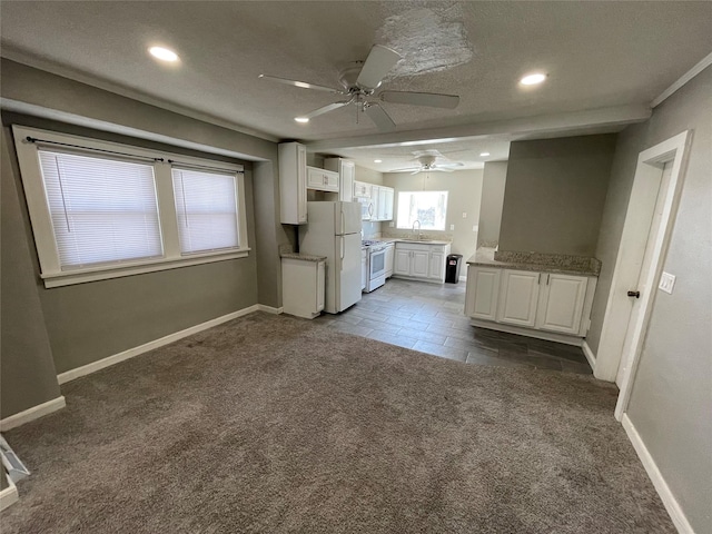 1144 Euclid Ave, Des Moines, IA 50313 - unfurnished living room with baseboards, ceiling fan, a sink, and dark colored carpet