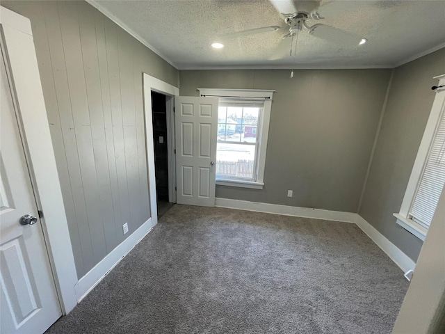 1144 Euclid Ave, Des Moines, IA 50313 - unfurnished bedroom with a textured ceiling, baseboards, ceiling fan, ornamental molding, and carpet floors