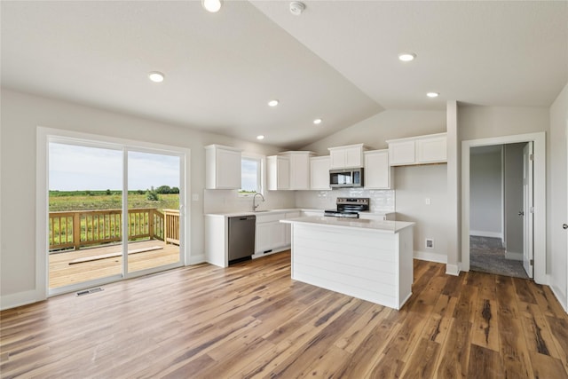 1430 Werthman Dr, Waukee, IA 50263 - kitchen with stainless steel appliances, light countertops, white cabinets, tasteful backsplash, and lofted ceiling