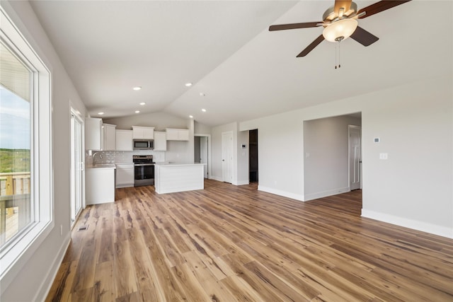 1430 Werthman Dr, Waukee, IA 50263 - unfurnished living room featuring lofted ceiling, light wood finished floors, ceiling fan, and recessed lighting