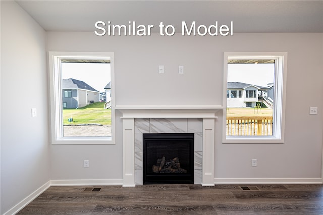 unfurnished living room featuring dark wood finished floors, a tiled fireplace, and baseboards