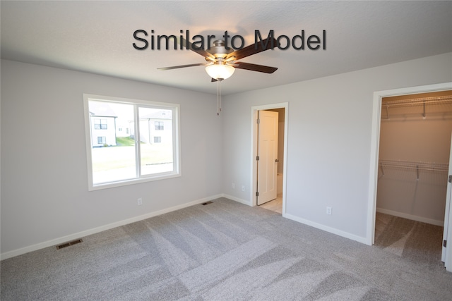 unfurnished bedroom featuring carpet, a spacious closet, baseboards, and a closet