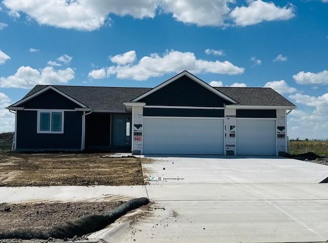 ranch-style home featuring a garage and driveway