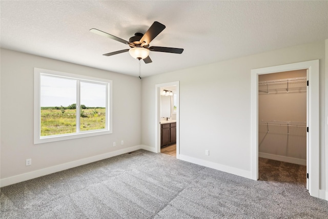 1440 Werthman Dr, Waukee, IA 50263 - unfurnished bedroom featuring light colored carpet, a spacious closet, ensuite bath, a closet, and a textured ceiling