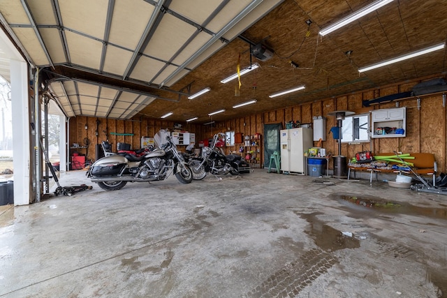 2141 320th St, Fort Dodge, IA 50501 - garage featuring white refrigerator with ice dispenser and a garage door opener