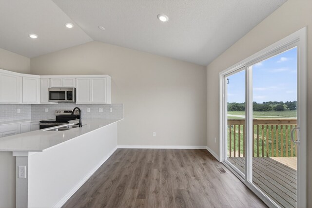 1911 20th Ave SE, Altoona, IA 50009 - kitchen with appliances with stainless steel finishes, lofted ceiling, healthy amount of natural light, light wood-style floors, and white cabinets