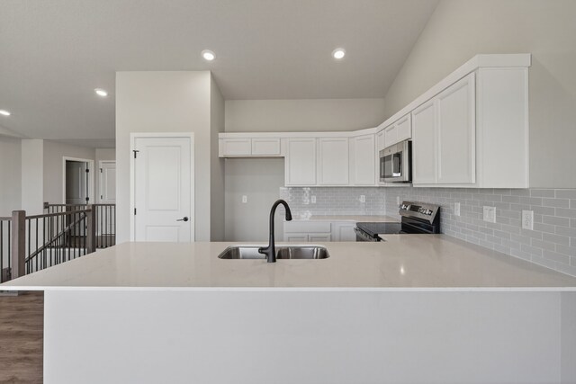 1911 20th Ave SE, Altoona, IA 50009 - kitchen with stainless steel appliances, a peninsula, backsplash, white cabinets, and recessed lighting