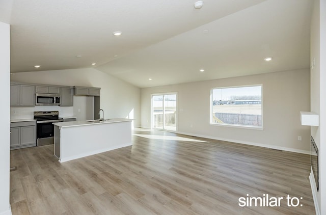 16614 Walnut Meadows Dr, Urbandale, IA 50323 - kitchen featuring lofted ceiling, open floor plan, a sink, appliances with stainless steel finishes, and gray cabinetry