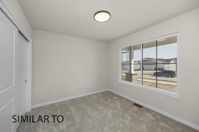 unfurnished bedroom with baseboards, visible vents, a closet, and carpet