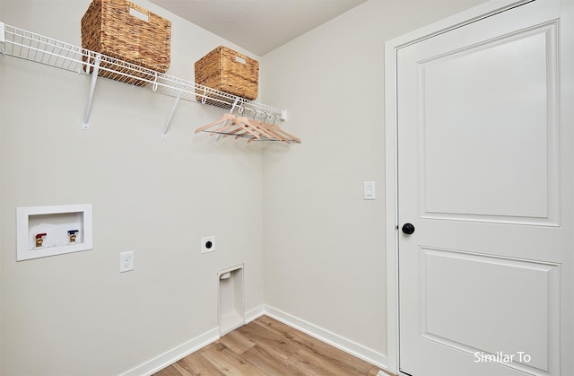 clothes washing area with hookup for a washing machine, hookup for an electric dryer, light wood-style flooring, baseboards, and laundry area