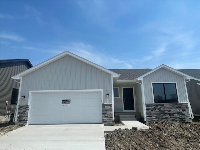 view of front of home featuring driveway, stone siding, and a garage