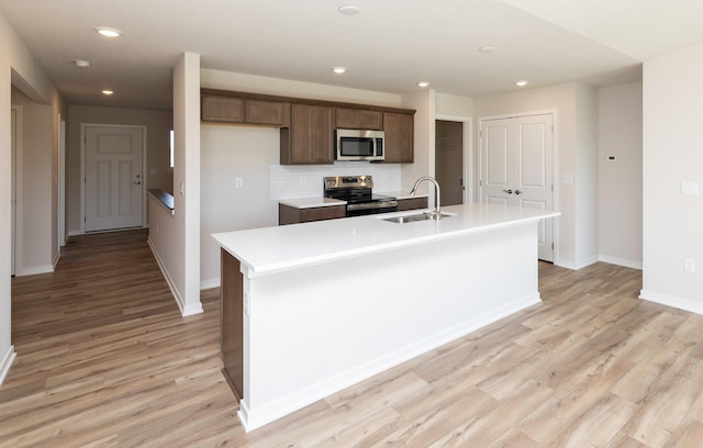 6411 NE 11th Ct, Des Moines, IA 50313 - kitchen featuring stainless steel appliances, a sink, an island with sink, recessed lighting, and light wood finished floors