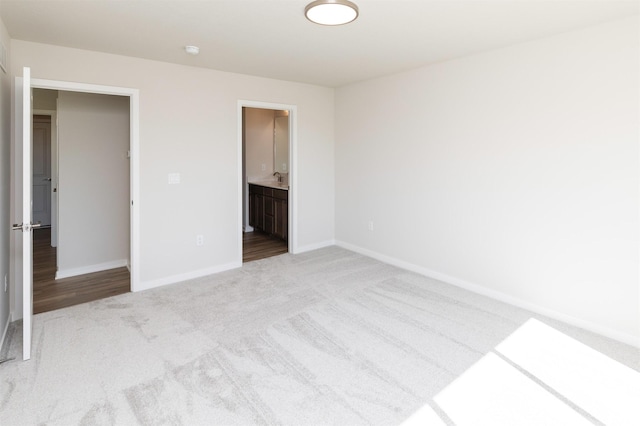 6411 NE 11th Ct, Des Moines, IA 50313 - unfurnished bedroom with carpet flooring, baseboards, and connected bathroom