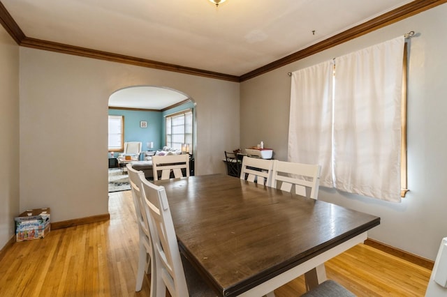 807 Virginia Ave, Des Moines, IA 50315 - dining area featuring light wood finished floors, ornamental molding, baseboards, and arched walkways