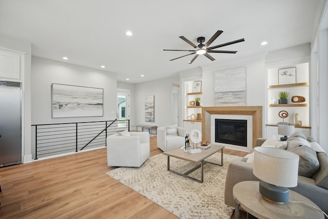 18167 Alderleaf Dr, Clive, IA 50325 - living area with ceiling fan, wood finished floors, recessed lighting, a glass covered fireplace, and built in features