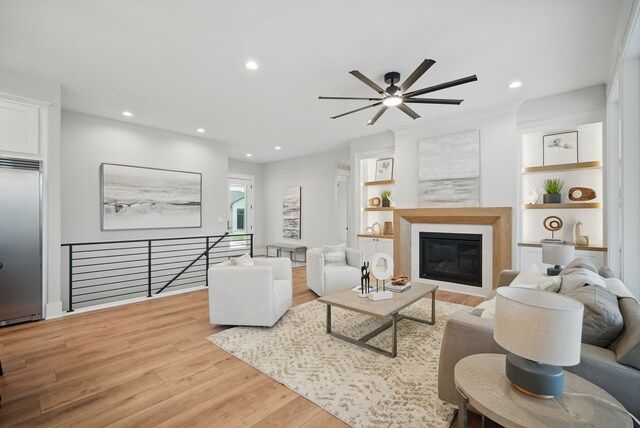 18167 Alderleaf Dr, Clive, IA 50325 - living area with a ceiling fan, wood finished floors, recessed lighting, a glass covered fireplace, and built in features