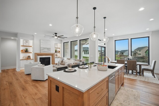 18167 Alderleaf Dr, Clive, IA 50325 - kitchen featuring a ceiling fan, a sink, light wood-style floors, recessed lighting, and a center island with sink