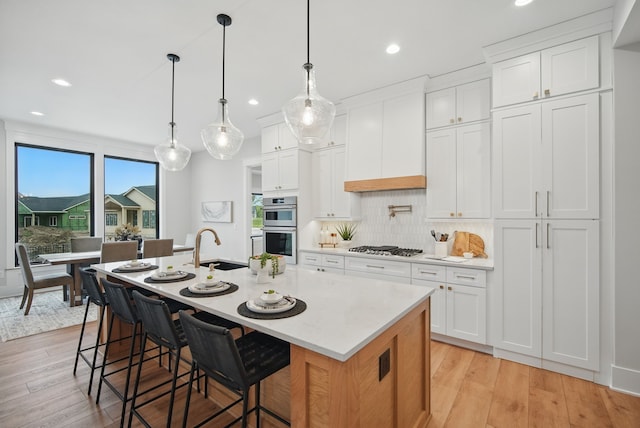 18167 Alderleaf Dr, Clive, IA 50325 - kitchen featuring appliances with stainless steel finishes, recessed lighting, light wood finished floors, decorative backsplash, and white cabinets