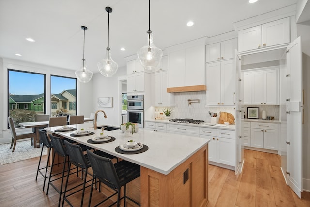 18167 Alderleaf Dr, Clive, IA 50325 - kitchen with recessed lighting, light wood-style floors, appliances with stainless steel finishes, decorative backsplash, and light countertops