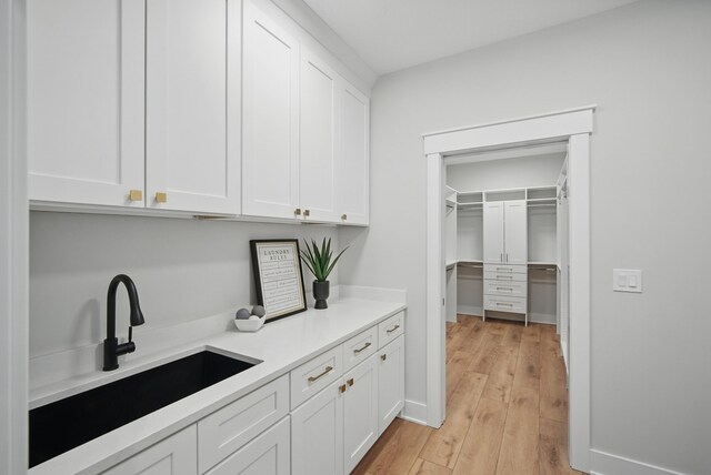 18167 Alderleaf Dr, Clive, IA 50325 - kitchen with a sink, white cabinets, light countertops, and light wood finished floors