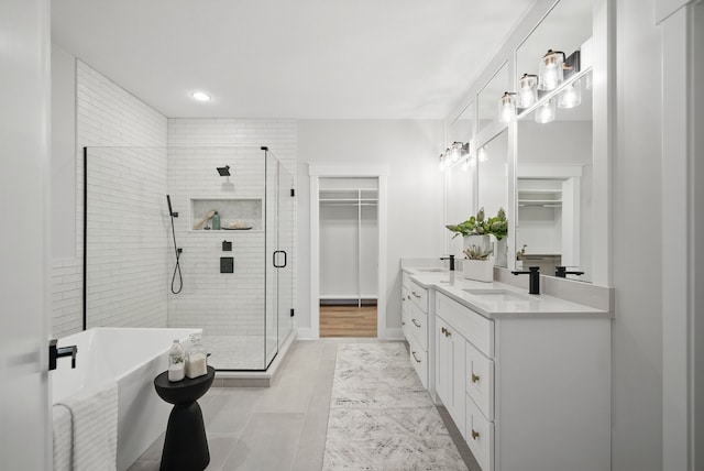 18167 Alderleaf Dr, Clive, IA 50325 - bathroom with double vanity, a shower stall, a spacious closet, a freestanding tub, and recessed lighting