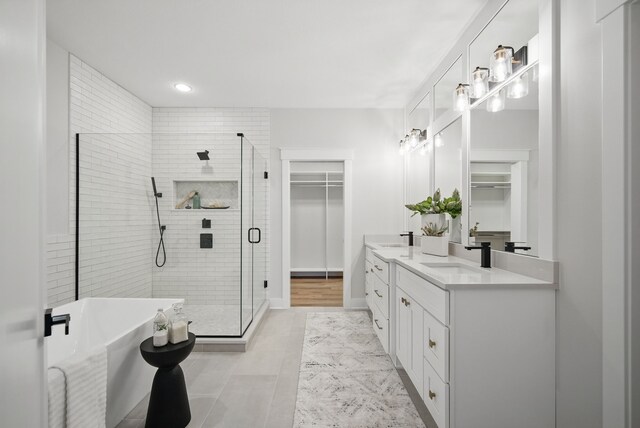 18167 Alderleaf Dr, Clive, IA 50325 - full bath featuring double vanity, a stall shower, a spacious closet, a soaking tub, and recessed lighting