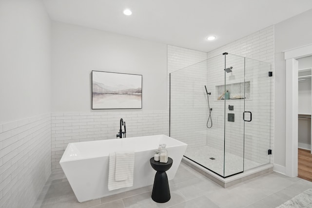 18167 Alderleaf Dr, Clive, IA 50325 - full bathroom with a soaking tub, a shower stall, tile walls, a walk in closet, and recessed lighting