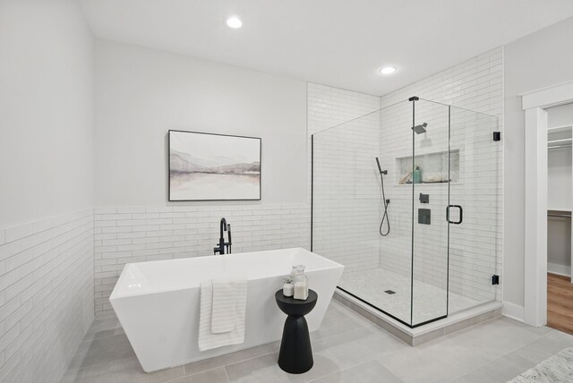 18167 Alderleaf Dr, Clive, IA 50325 - full bath with a freestanding tub, a stall shower, tile walls, a spacious closet, and recessed lighting