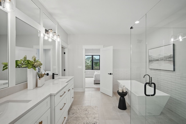 18167 Alderleaf Dr, Clive, IA 50325 - ensuite bathroom featuring double vanity, a freestanding tub, tile patterned flooring, an enclosed shower, and tile walls