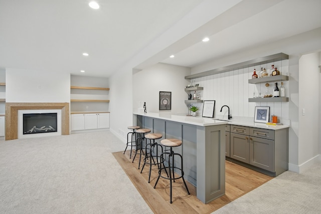 18167 Alderleaf Dr, Clive, IA 50325 - kitchen with open shelves, gray cabinetry, a kitchen bar, recessed lighting, and baseboards