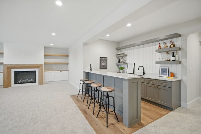 18167 Alderleaf Dr, Clive, IA 50325 - kitchen with open shelves, gray cabinetry, a kitchen bar, recessed lighting, and baseboards