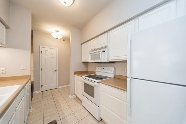 kitchen with light countertops, baseboards, light tile patterned floors, white appliances, and white cabinets