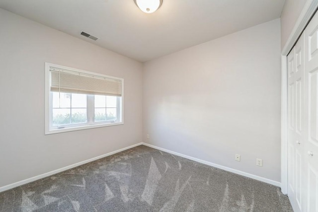 empty room with baseboards, visible vents, and carpet floors