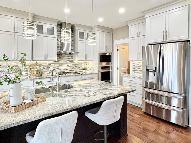 17595 Aurora Dr, Clive, IA 50325 - kitchen featuring stainless steel appliances, wall chimney range hood, a kitchen bar, decorative backsplash, and glass insert cabinets