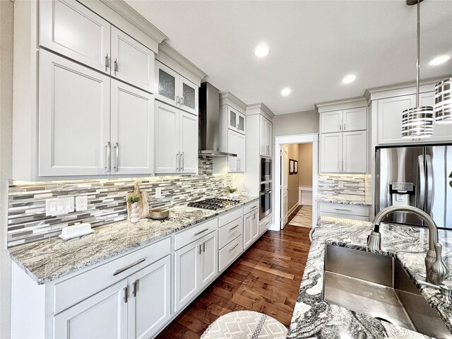 17595 Aurora Dr, Clive, IA 50325 - kitchen with appliances with stainless steel finishes, wall chimney exhaust hood, a sink, white cabinets, and dark wood finished floors