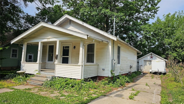 613 E 8th St N, Newton, IA 50208 - view of front facade featuring a porch, concrete driveway, and an outdoor structure