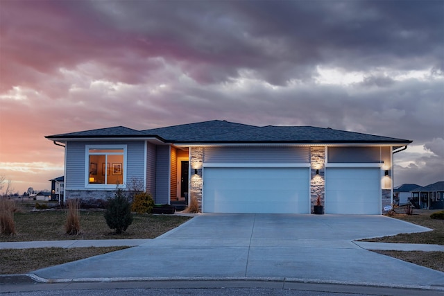view of front of house featuring a garage, stone siding, and concrete driveway
