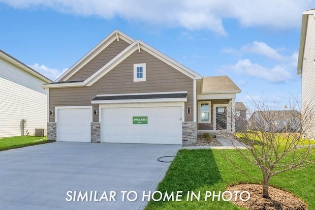 490 NW Independence Cir, Waukee, IA 50263 - craftsman-style home with stone siding, a garage, concrete driveway, and a front lawn