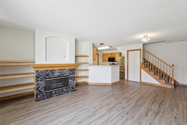 811 Burr Oaks Dr Unit 1110, West Des Moines, IA 50266 - living area with wood finished floors, stairway, and a premium fireplace