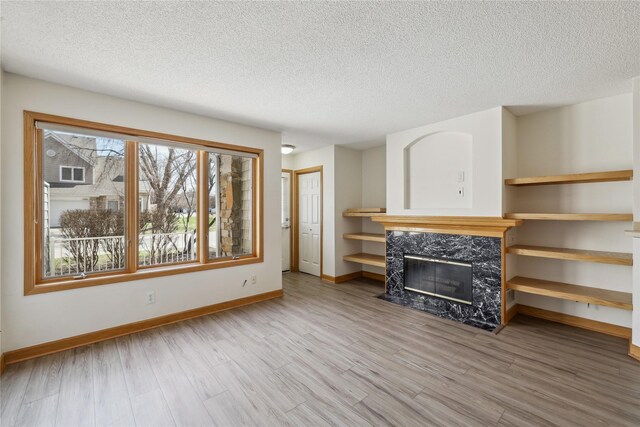 811 Burr Oaks Dr Unit 1110, West Des Moines, IA 50266 - living area with a high end fireplace, wood finished floors, and a textured ceiling