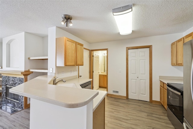811 Burr Oaks Dr Unit 1110, West Des Moines, IA 50266 - kitchen with electric range, light wood-style floors, light countertops, a peninsula, and a textured ceiling