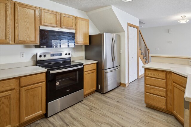 811 Burr Oaks Dr Unit 1110, West Des Moines, IA 50266 - kitchen featuring stainless steel appliances, light wood-style flooring, a textured ceiling, and light countertops