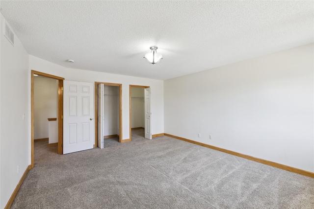 811 Burr Oaks Dr Unit 1110, West Des Moines, IA 50266 - unfurnished bedroom with carpet floors, a textured ceiling, and two closets