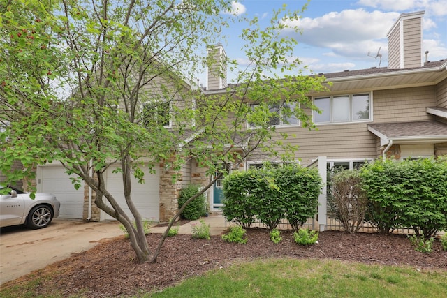 811 Burr Oaks Dr Unit 1110, West Des Moines, IA 50266 - view of front of home featuring a chimney, concrete driveway, stone siding, and roof with shingles