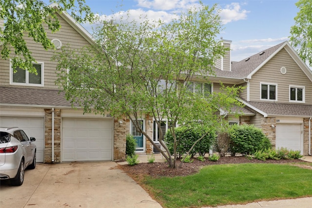 811 Burr Oaks Dr Unit 1110, West Des Moines, IA 50266 - view of property featuring stone siding, a shingled roof, concrete driveway, and a front yard