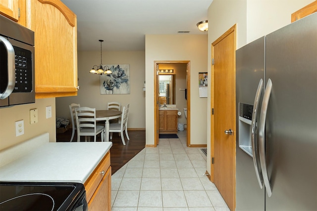 2819 Ashland Ct, Altoona, IA 50009 - kitchen featuring stainless steel appliances, light countertops, light tile patterned floors, hanging light fixtures, and a chandelier