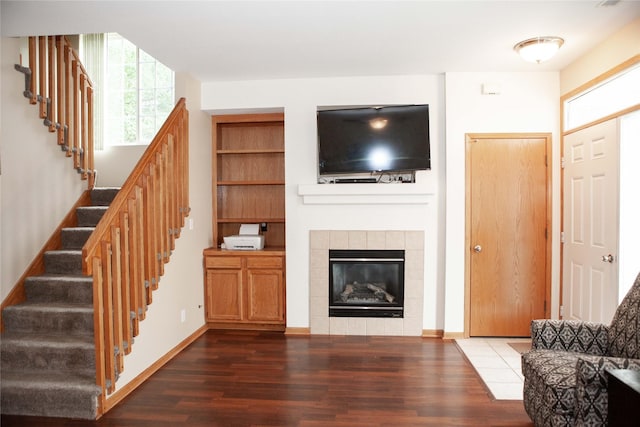 2819 Ashland Ct, Altoona, IA 50009 - living room with wood finished floors, stairs, and a tile fireplace